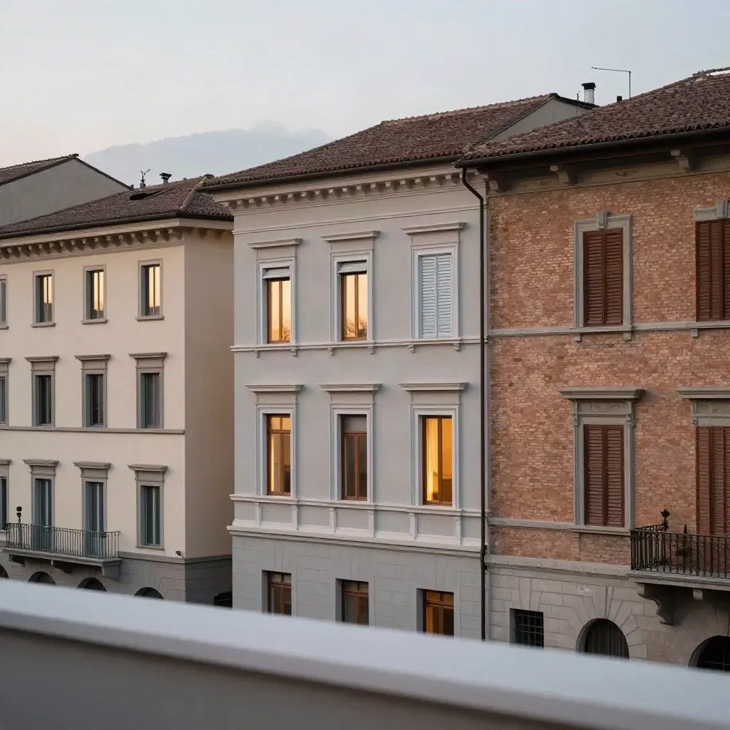 Tre facciate italiane al tramonto con luci interne che si accendono e foschia morbida.
